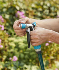 Person adjusting Front Control Garden Hose Nozzle With Adjustable Spray Pattern, Ergonomic Non Slip Grip in garden setting