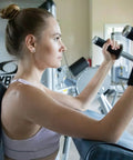 Woman using gym equipment wearing Right Hand Carpal Tunnel Wrist Brace For Men And Women Adjustable Wrist Splint With All Day Comfort