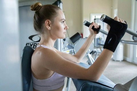 Woman using gym equipment wearing Right Hand Carpal Tunnel Wrist Brace For Men And Women Adjustable Wrist Splint With All Day Comfort