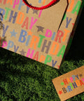 Large Kraft Birthday Gift Bag With Tissue Paper And Card 13 Inch Wide Horizontal Gift Tote With Colorful Happy Birthday Stars Design Great For Books Clothes Electronics And Gifting Boys Girls Men with card on grass