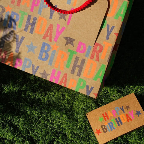 Large Kraft Birthday Gift Bag With Tissue Paper And Card 13 Inch Wide Horizontal Gift Tote With Colorful Happy Birthday Stars Design Great For Books Clothes Electronics And Gifting Boys Girls Men with card on grass