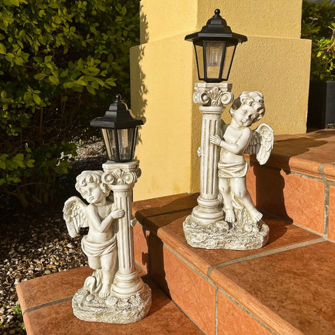 Lit Solar Angel Garden Statue With Roma Pillar For Outdoor Decor And Lawn Or Patio Nineteen Point Seven Inch Left Facing Angel That Lights Up At Night A Perfect Christian Gift For Garden Yard Or Porch displayed on steps