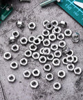 Top Shelf 50 Pack Stainless Steel Hex Nuts With Coarse Thread Built Tough Hardware Fasteners Precision Metal Nut Kit on a work surface.