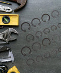 Steel Snap Ring Assortment Kit With Rotatable Circlips For Maintenance And Repair next to assorted tools on gray surface