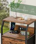 Night Stand With Built In Charging Station And USB Ports, 28.3 Inch Tall Bedside Table With Wood Shelf And 3 Fabric Drawers shown with devices charging