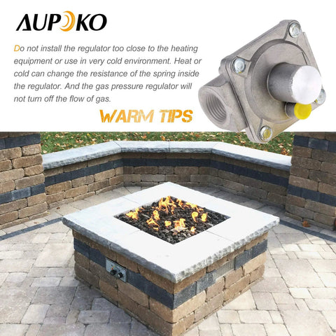 Aupoko natural gas grill regulator with 1/2-in NPT inlet/outlet, metal body, displayed above an outdoor stone fire pit.