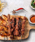 10-inch stainless steel square barbecue skewers, six skewers laid on a wooden board with grilled kebabs