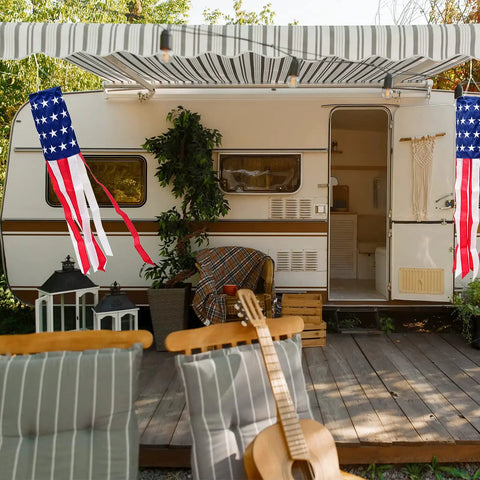 Patriotic Windsock 40 Inch With Embroidered Stars hanging on a porch beside a trailer, showcasing American flag theme outdoor decor.