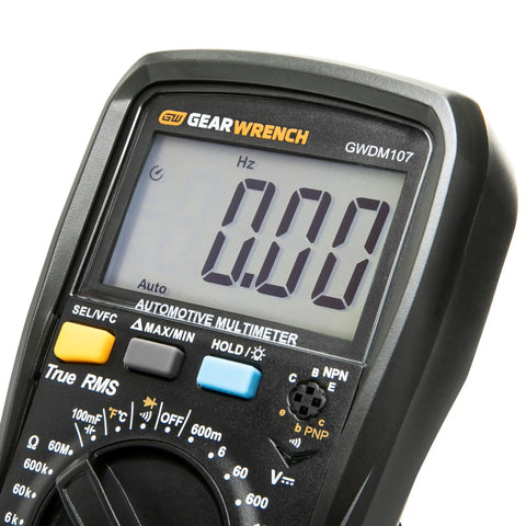 Close-up of Automotive Pro Grade Digital Multimeter With True RMS, displaying 0.00 Hz on screen, buttons and dial visible.