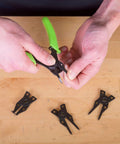 Person using 4 In 1 Snap Ring Pliers Set For Internal And External Rings, with interchangeable jaws, on wooden surface