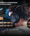 Person wearing DT 1990 Pro MKII Open-Back Wired Studio Headphones For Mixing And Mastering, 30 Ohm, black design in a studio.