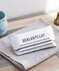 Sealant clay packaging on a cloth in a home setting, used for DIY sealing putty for wall holes and cracks waterproof duct mastic sealant paste.