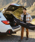 Man carrying a Portable Hammock Stand 15 Lb Lightweight With Quick Setup And Chair Mode Carry Bag And Straps near car in desert.