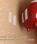 Premium Recloseable Fastener Tape Strips One By Two Inch Clear Heavy Duty Adhesive Pad Ten Pack on a wall holding a red object.