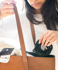 Woman placing Grounding Blanket Throw Kit With Ground Therapy Coil Cord, 44 By 68 Inch, in a brown bag.