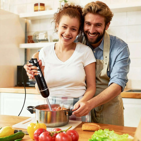 Badass 700W Immersion Hand Blender With 20 Precise Speed Options For Buttery Smooth Purees And Rapid Ingredient Prep In Any Home Kitchen Total Game Changer Black Finish in use by couple making soup.