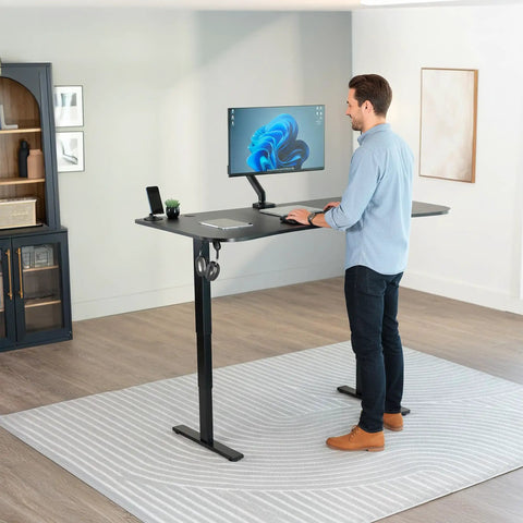 Vivo Black Sit Stand Desk Electric Height Adjustable 63 Inch Wide Ergonomic Workstation Two Monitor Ready with user standing.