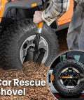 Person using a car rescue shovel with an orange handle near a tire. Close-up of shovel stored on car wheel.