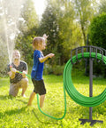 Detachable Metal Garden Hose Holder Stand With Upgraded Four Spike Design Heavy Duty Freestanding Hose Reel Rack And Outdoor Hose Storage Organizer Keeps Your Yard Neat And Hoses Ready To Roll in use in a garden setting with people enjoying water spray.