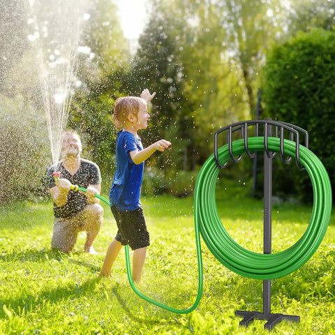 Detachable Metal Garden Hose Holder Stand With Upgraded Four Spike Design Heavy Duty Freestanding Hose Reel Rack And Outdoor Hose Storage Organizer Keeps Your Yard Neat And Hoses Ready To Roll in use in a garden setting with people enjoying water spray.