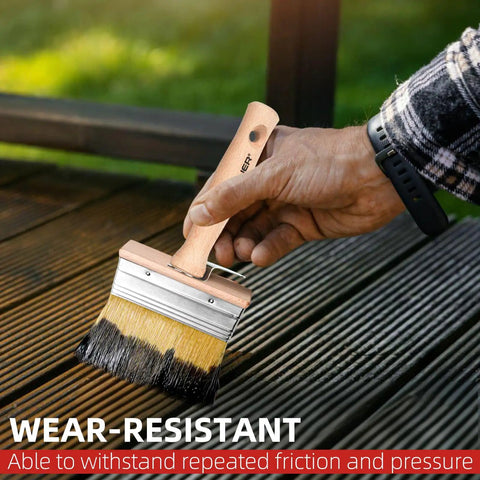 Hand using large brush from 3-Piece Deck Stain Brush Set for Limewash and Wood Stain on a wooden deck