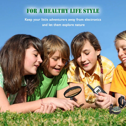 Children using Outdoor Adventure Kit For Kids With Real Walkie Talkies, Binoculars, Flashlight, Compass, Magnifier, Whistle, Camouflage Hat And Backpack For Backyard Missions, Park Explorations, And Indoor Quests in a grass field.