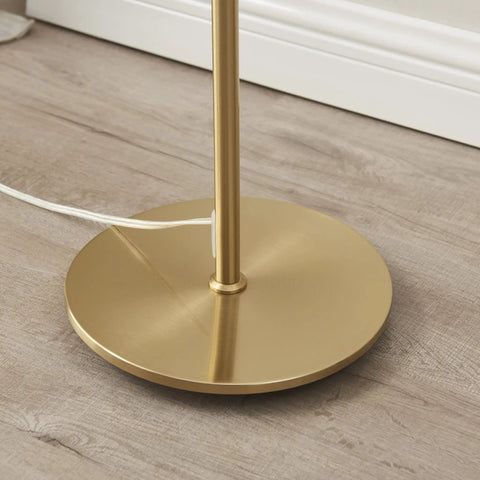 Base of Rowan Brass Floor Lamp With Unique Thread Shade, showing round brass base on wooden floor.