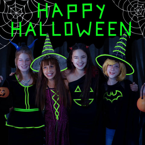 Group of children in Halloween costumes with glow in dark outfits under 'Happy Halloween' sign, showcasing spooky decor.