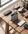 Portable Smart Dual Battery Charger Hub For Drones charging two batteries and powering devices on a wooden table setup.