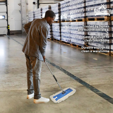 Man using Top Shelf 24 Inch Cotton Dust Mop Kit With Heavy Duty Aluminum Handle For Dead Easy Floor Sweeping And Hardwood Dust Pick Up In Commercial Home Or Business Spaces in a warehouse.