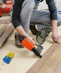 Real Deal Air Brad Nailer With Quick Release Bottom Load Magazine And 1000 18G Type 180 Brads To Knock Out Woodworking Projects In Bold Orange Carry Case in use on flooring.