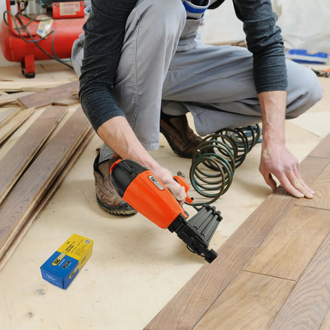 Real Deal Air Brad Nailer With Quick Release Bottom Load Magazine And 1000 18G Type 180 Brads To Knock Out Woodworking Projects In Bold Orange Carry Case in use on flooring.