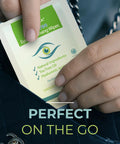 Front view of a NOVEHA eyelid and lash wipe sachet with green label being pulled from a handbag for eye cleansing.