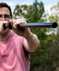 Professional.625 Cal Blowgun For Hunting 4 Foot Length White Red Black in use outdoors, dart in flight.