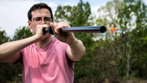 Professional.625 Cal Blowgun For Hunting 4 Foot Length White Red Black in use outdoors, dart in flight.