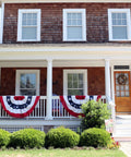 Patriotic Bunting Flags Set Of 6 Three Foot Long Outdoor Indoor Decoration Flags With Brass Grommets for Fourth of July displayed on porch.