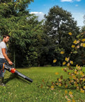 Man using 12 Amp Electric Leaf Blower With Turbine Tech for yard cleanups, blowing leaves on grass, WG520 model in action