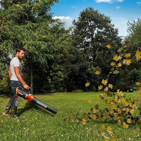 Man using 12 Amp Electric Leaf Blower With Turbine Tech for yard cleanups, blowing leaves on grass, WG520 model in action