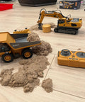 11 Channel RC Excavator Toy For Kids 3-12, Metal Construction Truck with sand, remote control, and loader on floor