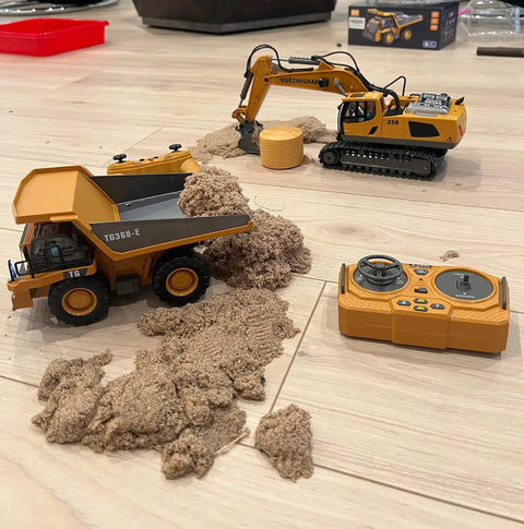 11 Channel RC Excavator Toy For Kids 3-12, Metal Construction Truck with sand, remote control, and loader on floor