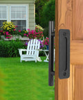 12 Inch Sliding Barn Door Handle Pull With Flush Back Plate, Matte Black Powder Coated Finish, installed on wood door, garden view