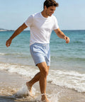 Man wearing 5 Inch Quick Dry Swim Trunks For Guys With Stretch Fabric And Zip Pockets Lightweight Beach Shorts walking on beach
