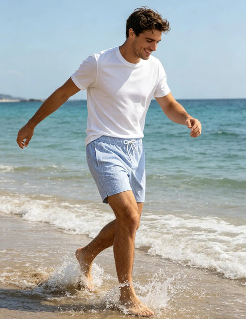 Man wearing 5 Inch Quick Dry Swim Trunks For Guys With Stretch Fabric And Zip Pockets Lightweight Beach Shorts walking on beach