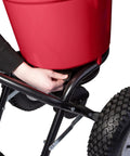 Adjusting drop rate on Heavy Duty 50 Lb Broadcast Fertilizer Spreader for Lawns with large 13 inch pneumatic stud tires.