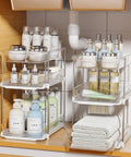 Total Game Changer Clear Three Tier Under Sink Organizer Two Pack with adjustable dividers holding beauty products and towels.