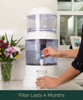 Person using Replacement Filter For Gravity Water System That Reduces Fluoride And Chlorine, Builds Alkaline Water, Adds Essential Minerals