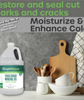 All American Food Grade Mineral Oil For Wood Care Keeps Your Cutting Boards Butcher Block Counters And Stainless Steel Smooth Protected And Ready For Action Odorless Tasteless Colorless 1 Gallon bottle next to wooden utensils and boards.