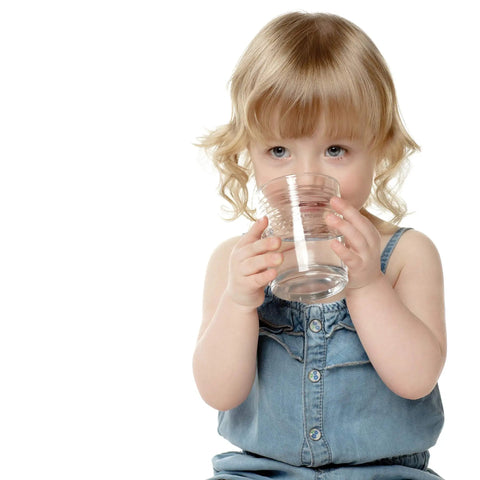 Young child in denim dress drinking water, highlighting use of Replacement Alkaline Filter For 109 Water Pitcher 2 Pack Boosts Water Alkalinity