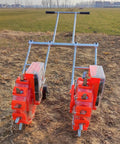 Hand Push Garden Seeder With Roller Seeders in field, showcasing red wheels, adjustable row spacing for home and farm use.