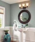 Oil Rubbed Bronze 8 Inch Widespread Bathroom Faucet For 3 Hole Vanity With Metal Push Pop Drain Assembly No Sweat DIY Install And Reliable Quality With Long Lasting Performance, installed on a white pedestal sink below bronze mirror.